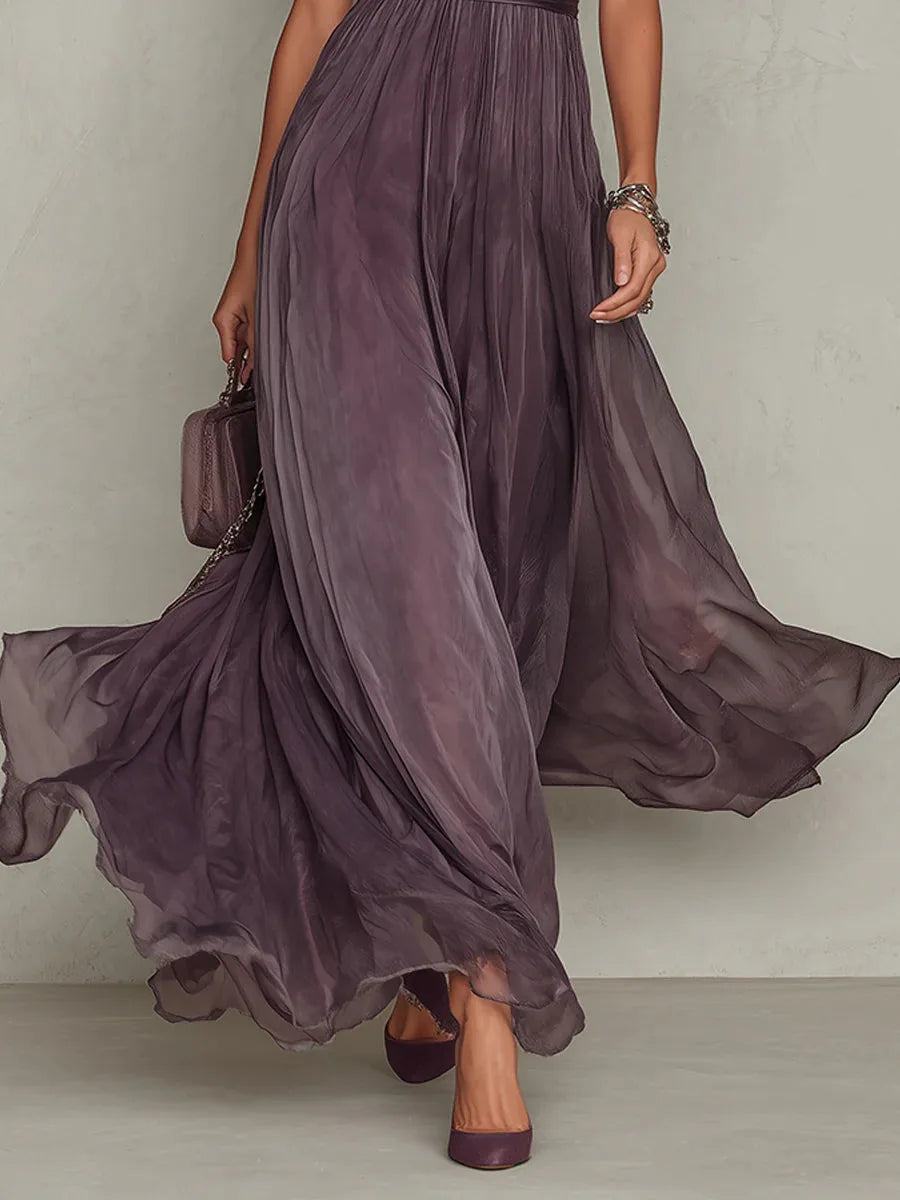 Close-up of the flowing pleated skirt in motion, showing the soft ombre plum tone and sheer chiffon layers