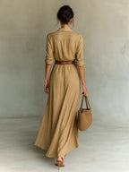 Back view of the beige wrap maxi dress showing the collared neckline, fitted waist and flowing skirt from behind