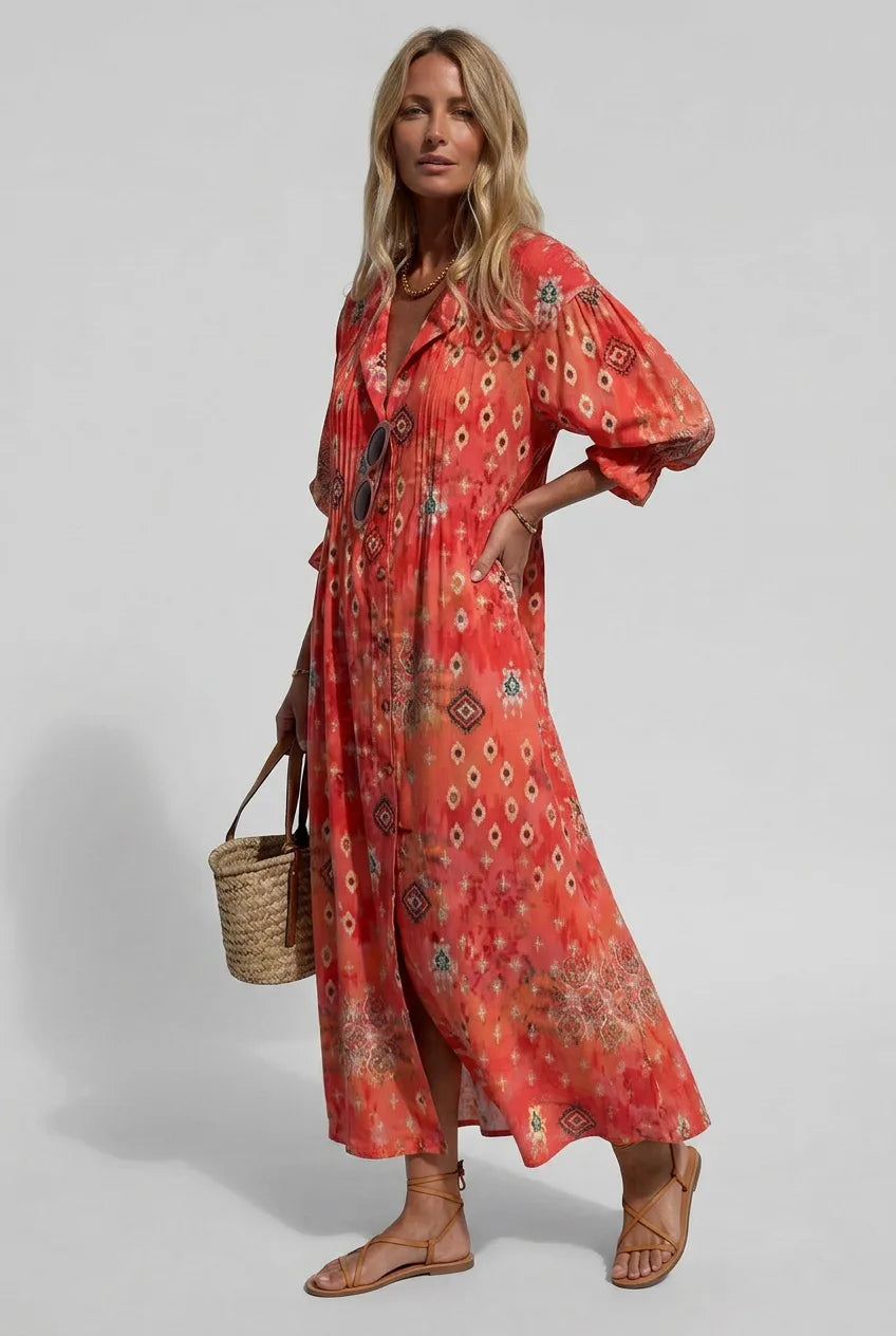 Woman modelling a coral red shirt dress with an ikat and ditsy print, hand on hip, pleated bodice detail