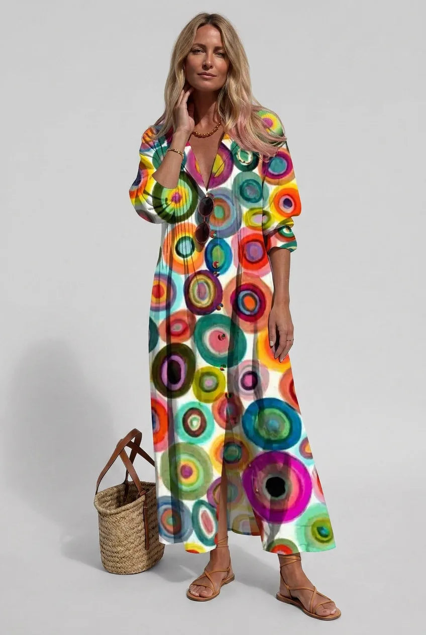 Side angle of a woman walking in a printed linen shirt dress showing the flowing maxi silhouette and slit hem