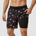 Front view of black swim shorts with pink flamingo print, pocket pulled open to reveal black compression liner with phone pocket