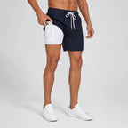 Side view of man wearing navy swim shorts with white compression liner, pulling a phone from the inner pocket