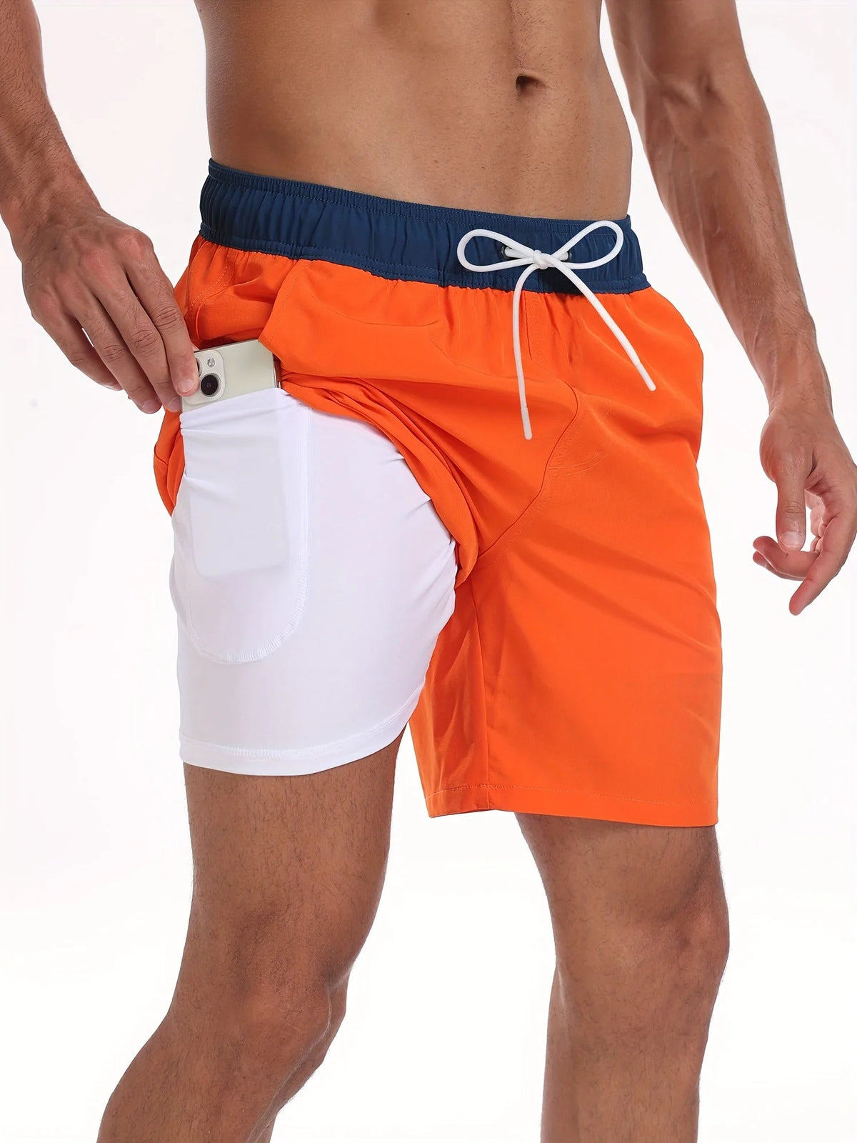 Close-up detail of orange swim shorts with navy waistband and white drawcord, showing inner pocket construction