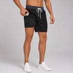 Side profile of black swim shorts with grey waistband and white compression liner underneath