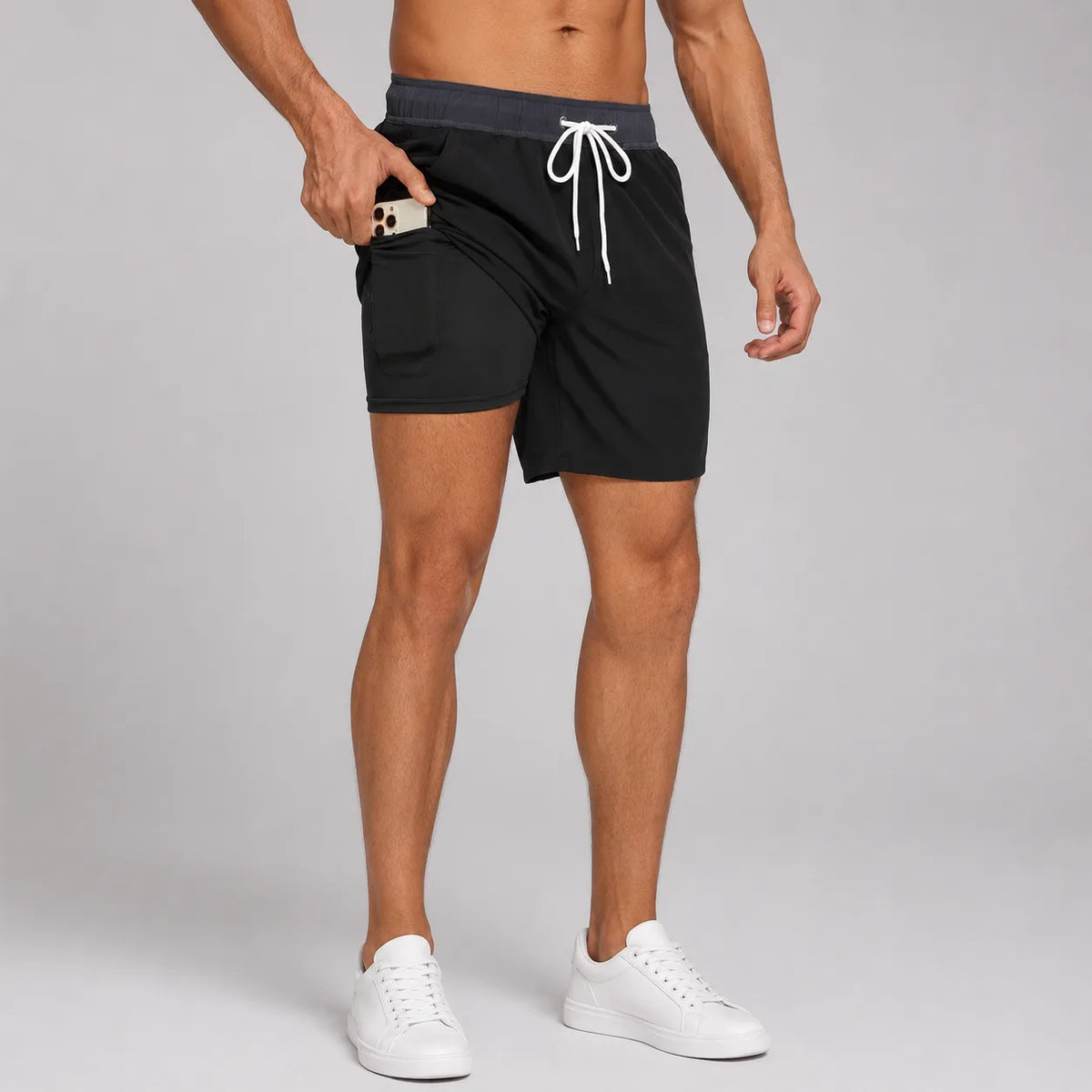 Side profile of black swim shorts with grey waistband and white compression liner underneath