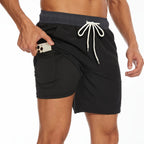 Close-up of black swim shorts showing white drawstring and inner pocket with phone being placed inside
