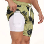Close-up of green palm leaf print swim shorts showing white compression liner and inner pocket with phone