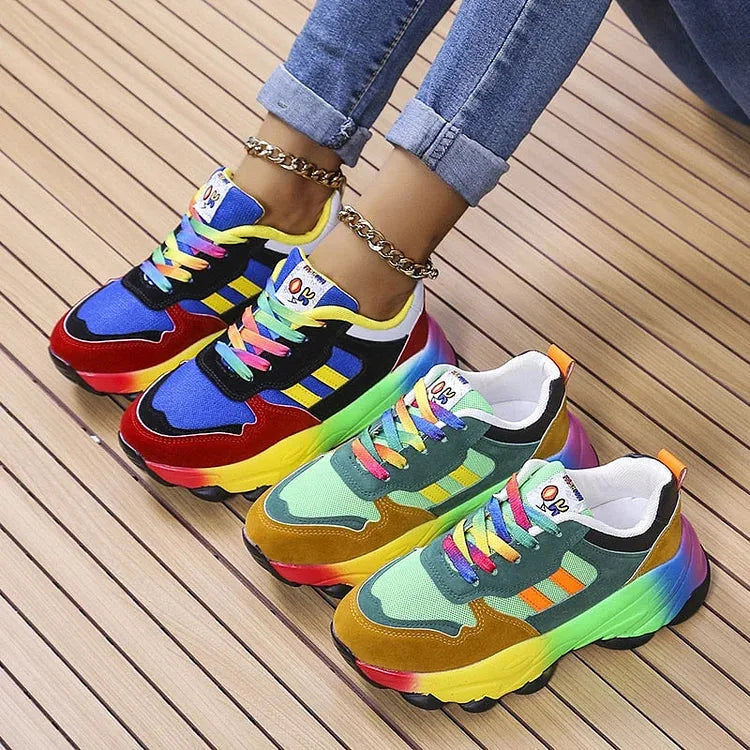 Pair of chunky rainbow sneakers side by side, one in blue and red, one in green and mustard colourway