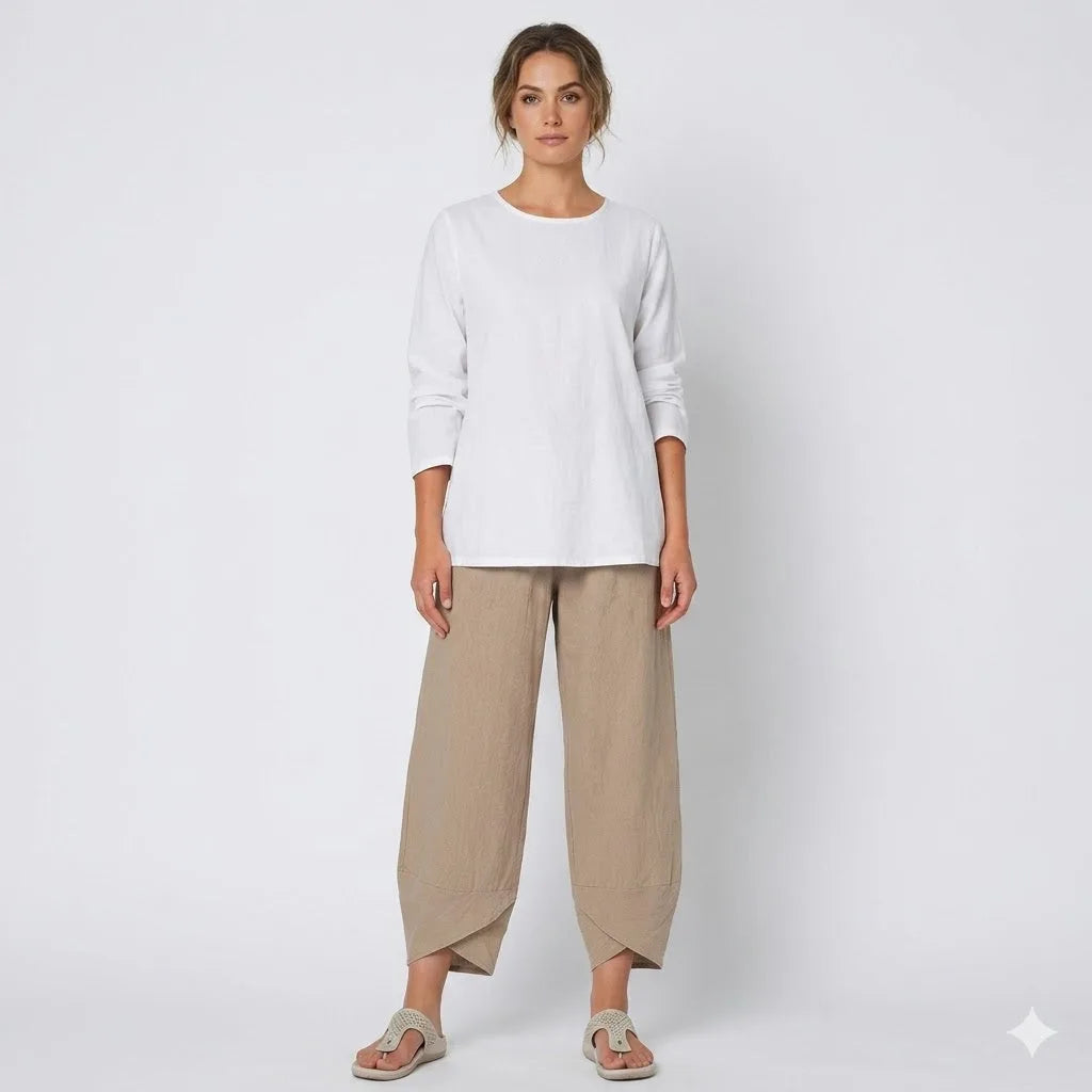 Woman wearing a white long-sleeve top with relaxed tan linen-blend pants and knit sandals, full-length front view