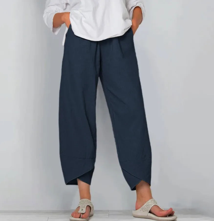 Front view of navy blue linen-blend pants highlighting the soft drape and curved cropped hemline