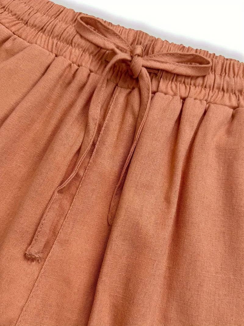Close-up of the elastic drawstring waistband and tied bow detail on the linen pants