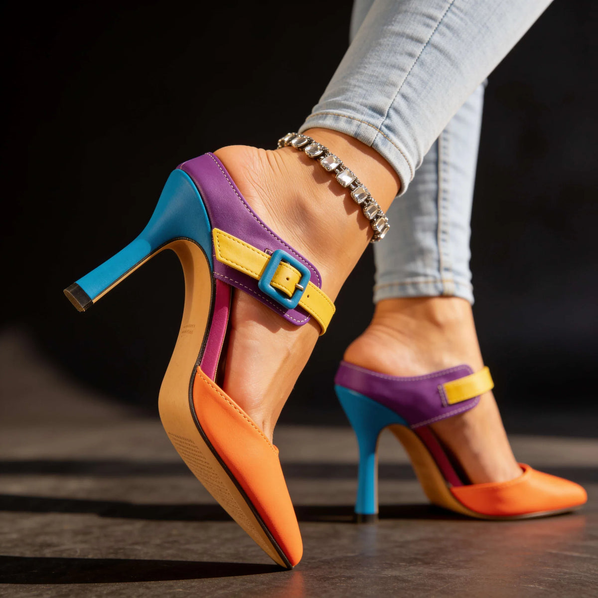 Back view of stiletto heel showing teal heel post, pink lining and purple topline with buckle strap
