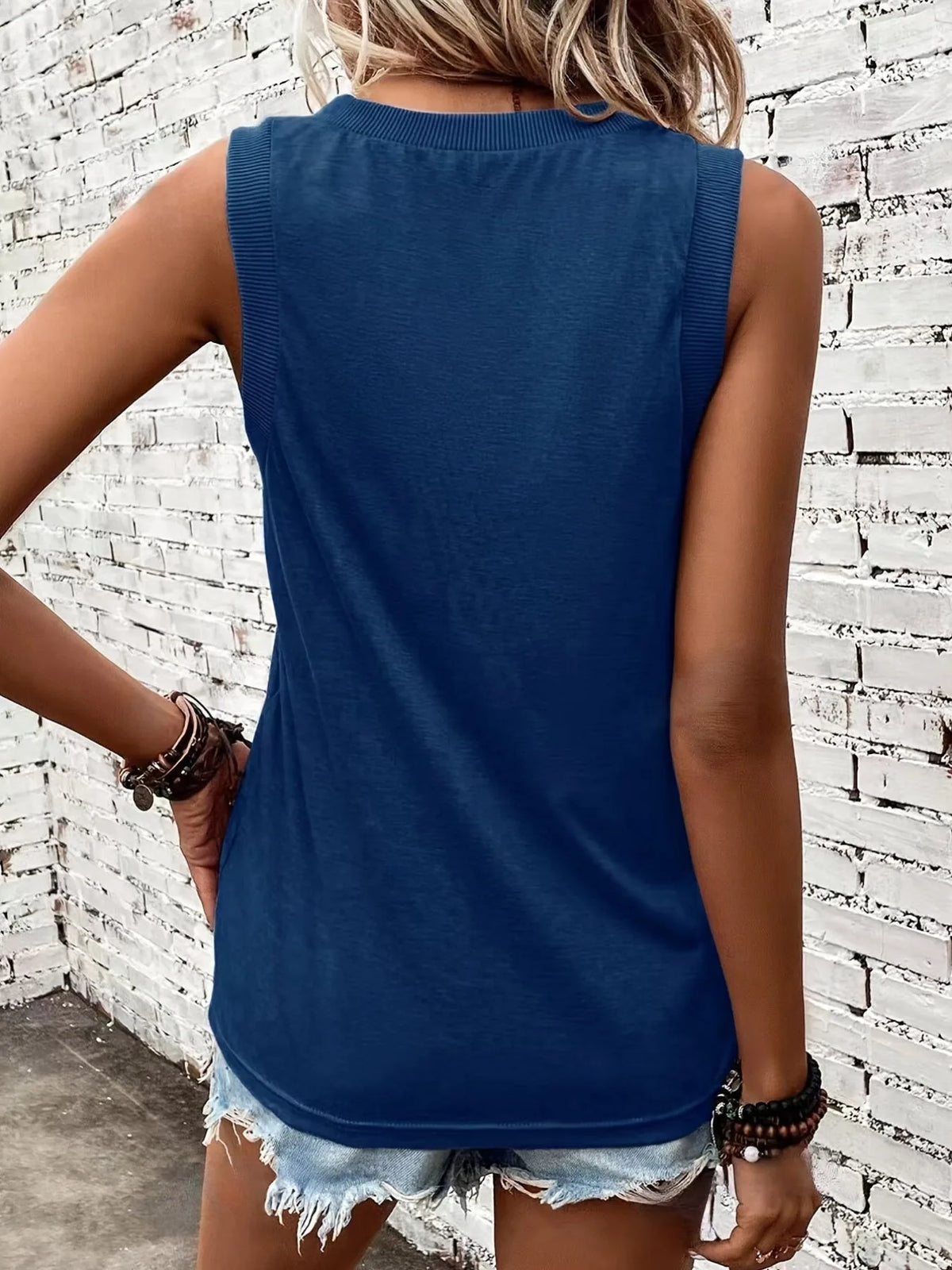Back view of the navy blue singlet highlighting the ribbed trim and curved dropped hem