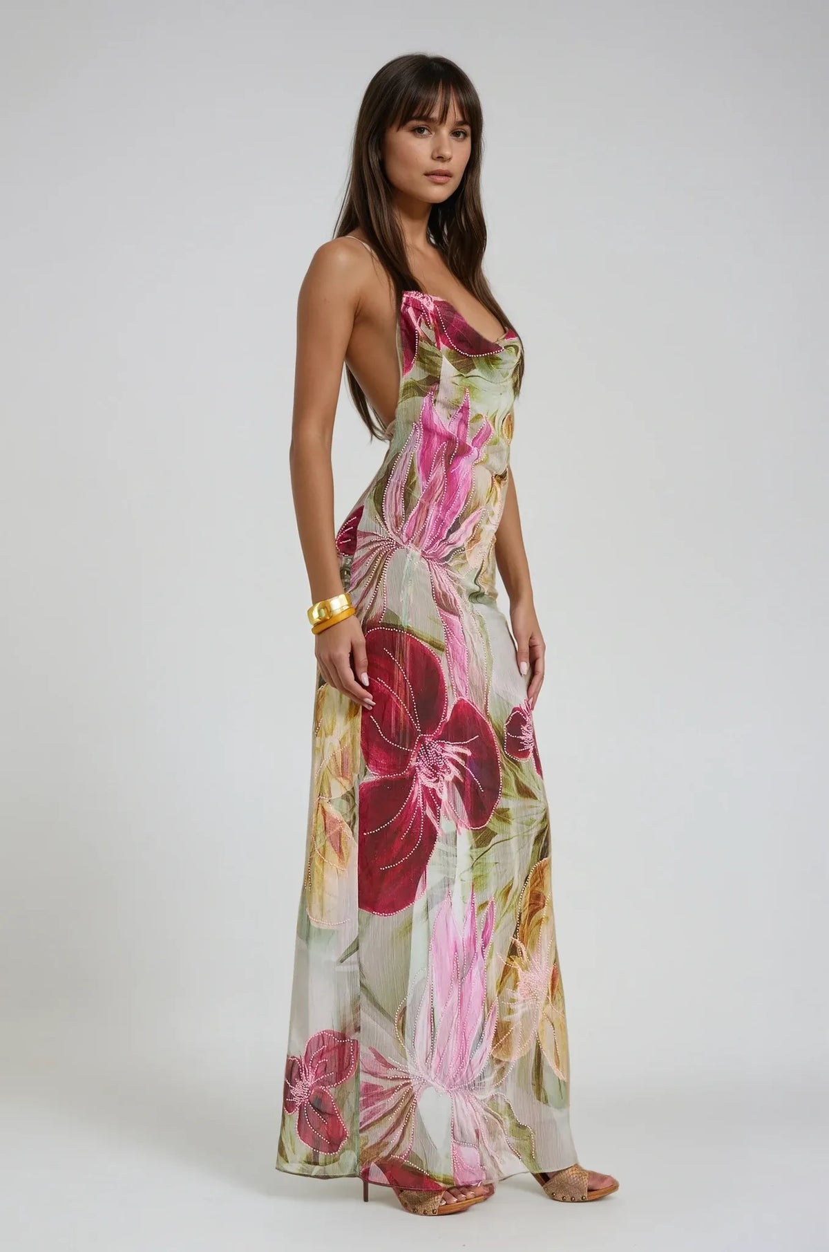Studio shot of the floral maxi dress on a model showing the cowl neckline, open back and flowing floor length skirt