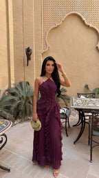 Model walking outdoors in yellow pleated maxi dress showing the asymmetrical ruffle skirt in motion