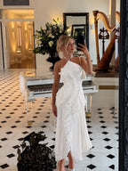 Front view of the dress highlighting the sculptural ruffle running from shoulder to hem