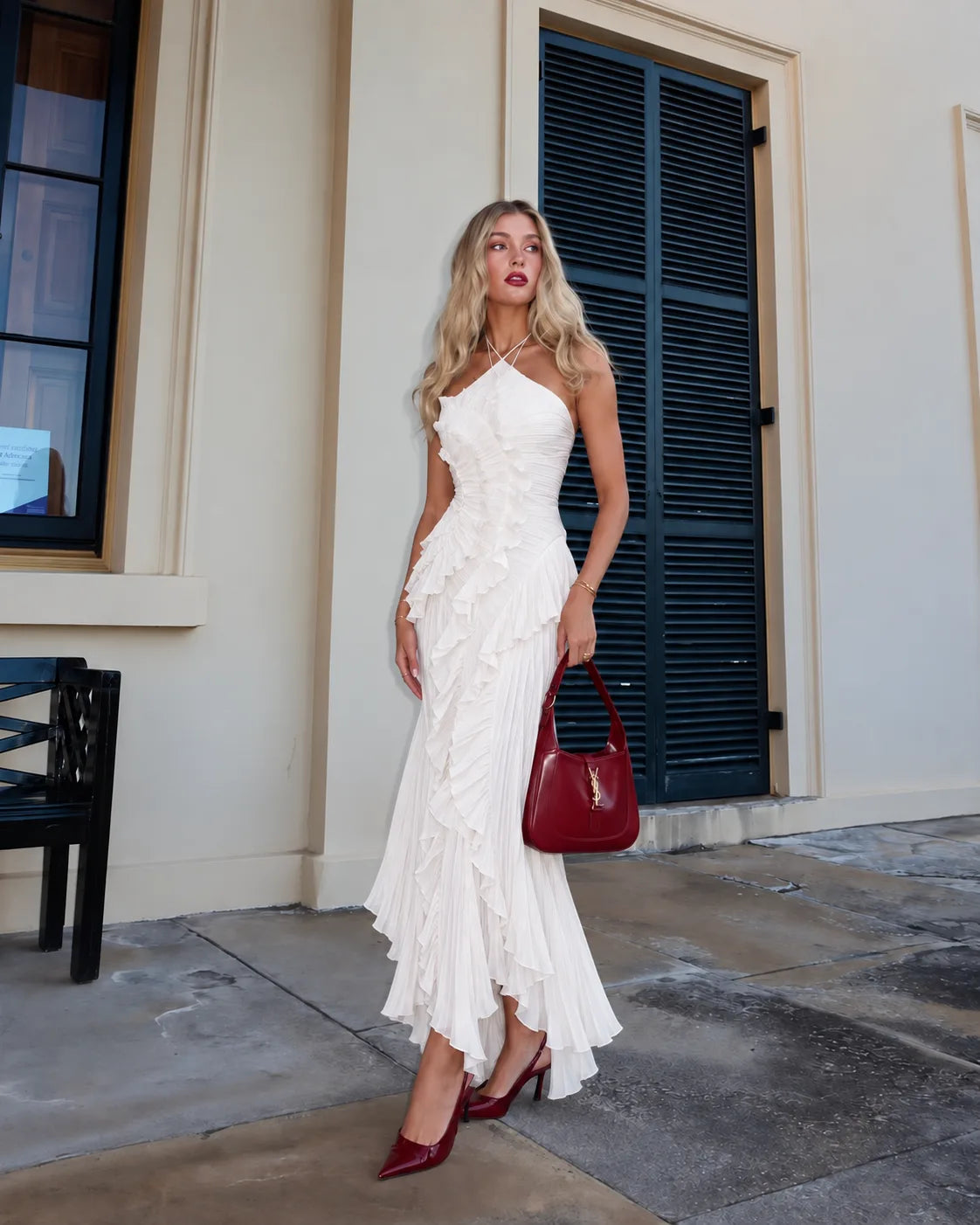 Model walking down stairs wearing the pleated halter maxi dress in soft evening light