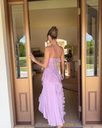 Full length front view of yellow pleated halter maxi dress on a model against a plain wall