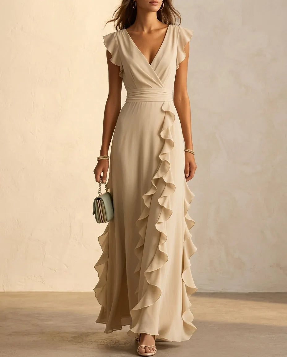 Khaki toned ruffle maxi dress with flutter sleeves and wide pleated waist, worn with heeled sandals