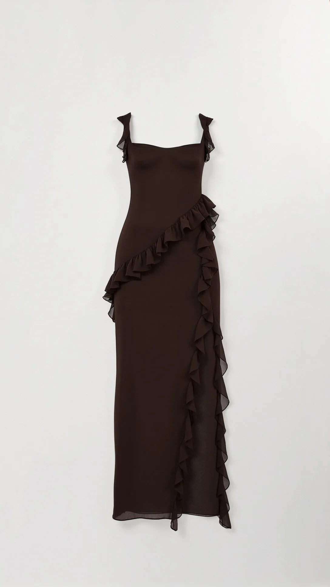Dark brown ruffled maxi dress shown flat on a hanger, highlighting the diagonal ruffle overlay and tie straps