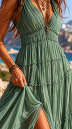 Close-up of the pleated bodice and tiered skirt in sage green chiffon, showing the fabric's texture and leg slit detail