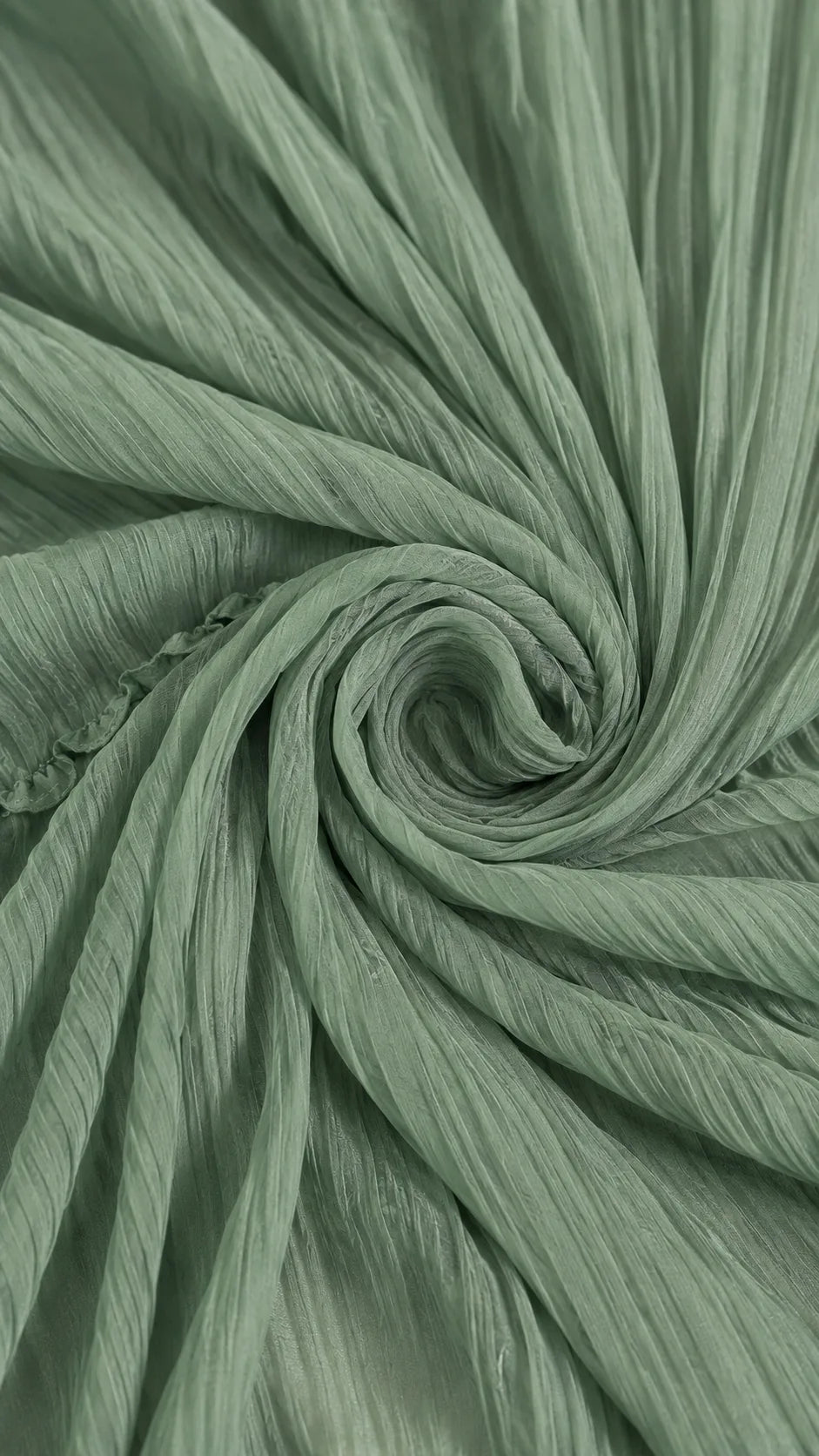 Macro shot of the finely pleated sage green fabric twisted to highlight its soft, crinkled texture and drape