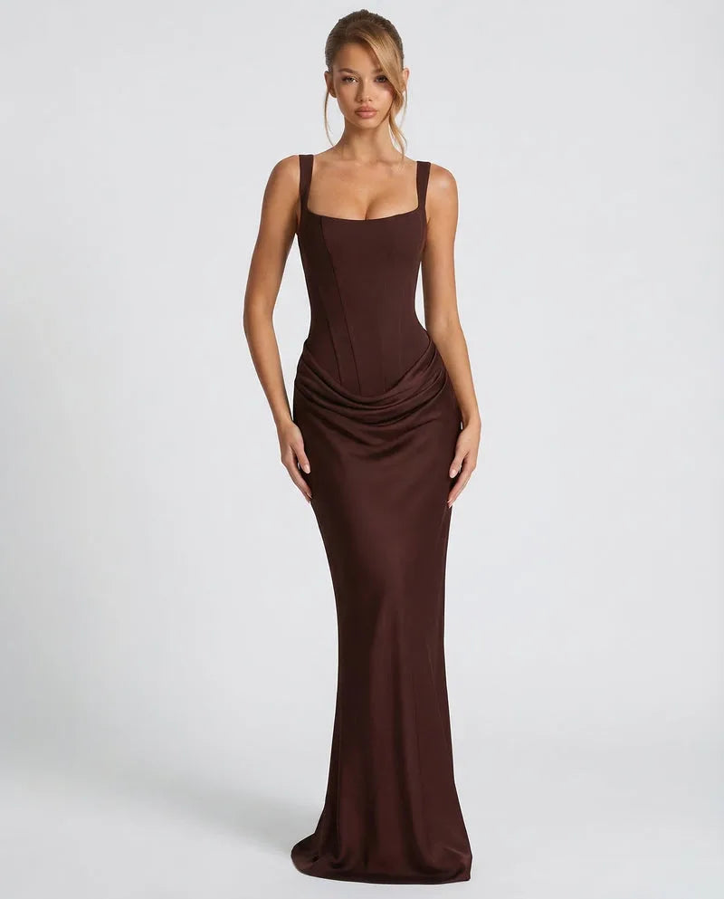 Front view of a model in a deep brown satin corset maxi dress with a square neckline and draped skirt