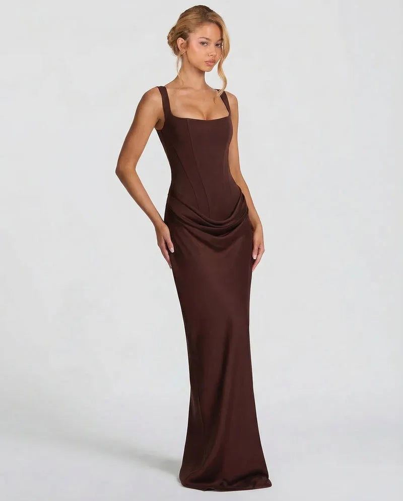 Side angle of the brown satin maxi dress highlighting the fitted boned bodice and ruched hip drape