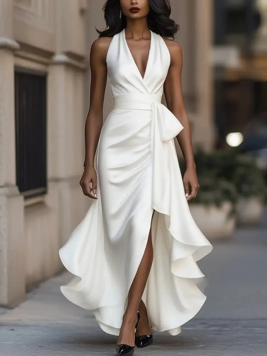White satin wrap-style maxi dress with halter neck, draped bodice and flowing asymmetric ruffled hemline