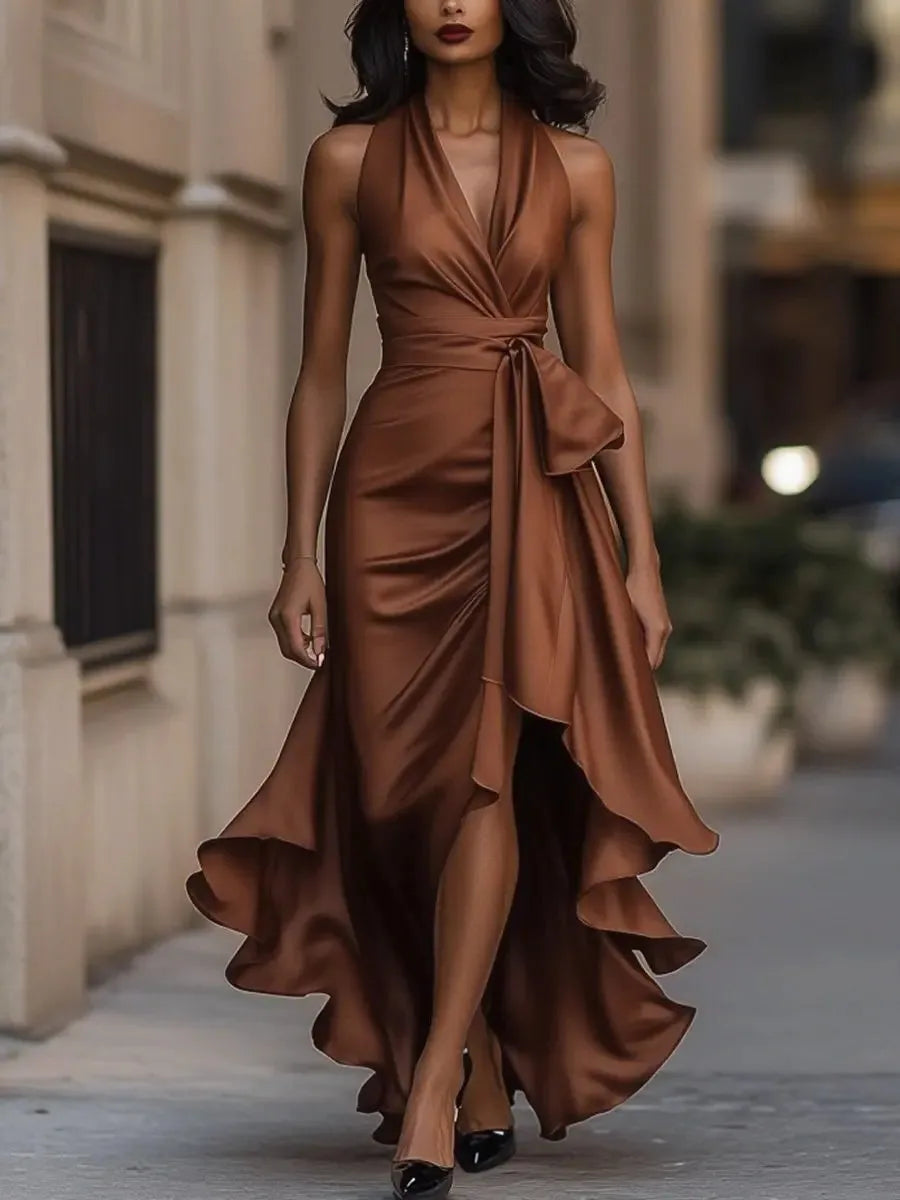 Brown satin halterneck wrap maxi dress with draped V neckline and layered ruffle hem, walking pose