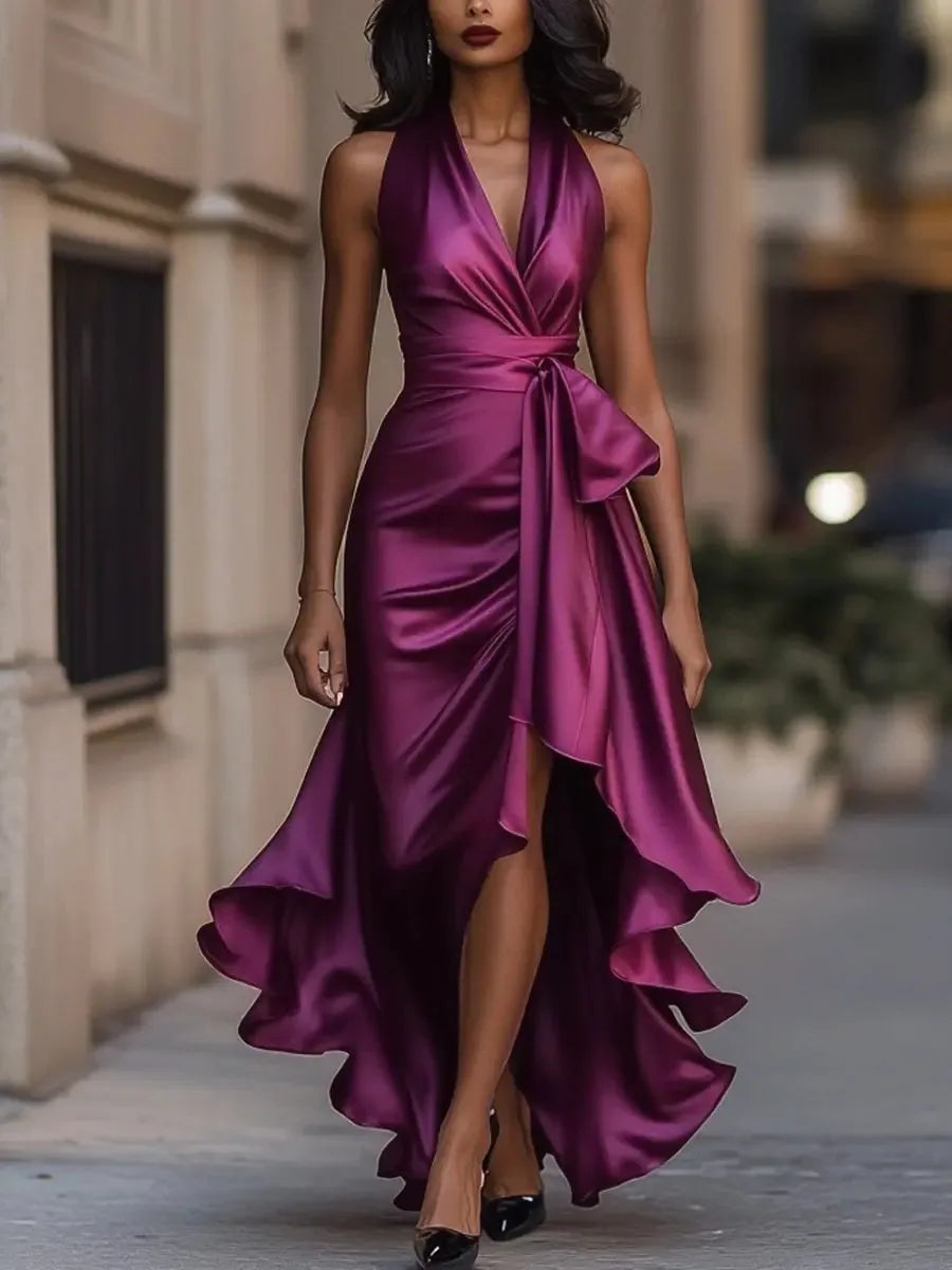 Dark pink satin halterneck maxi dress with cinched tie waist and flowing ruffled skirt panel
