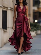 Burgundy satin halterneck maxi dress with plunging neckline, bow waist and voluminous ruffled hemline