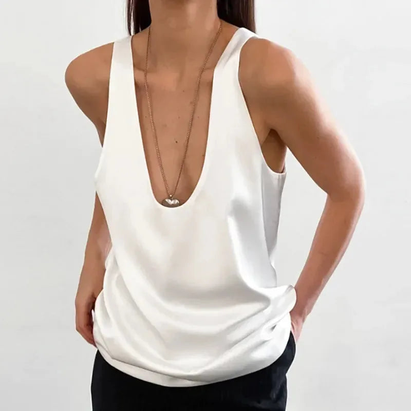 White satin tank top worn with black trousers, close crop showing the racerback straps and fabric sheen