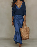 Full outfit view showing the satin slip maxi dress and knit jumper set with a woven straw tote