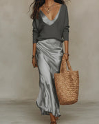 Grey satin slip maxi dress styled with a charcoal V-neck jumper layered on top