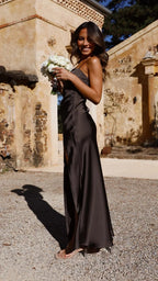 Side view of the black satin maxi dress showing the fitted waist ruching and glossy fabric sheen