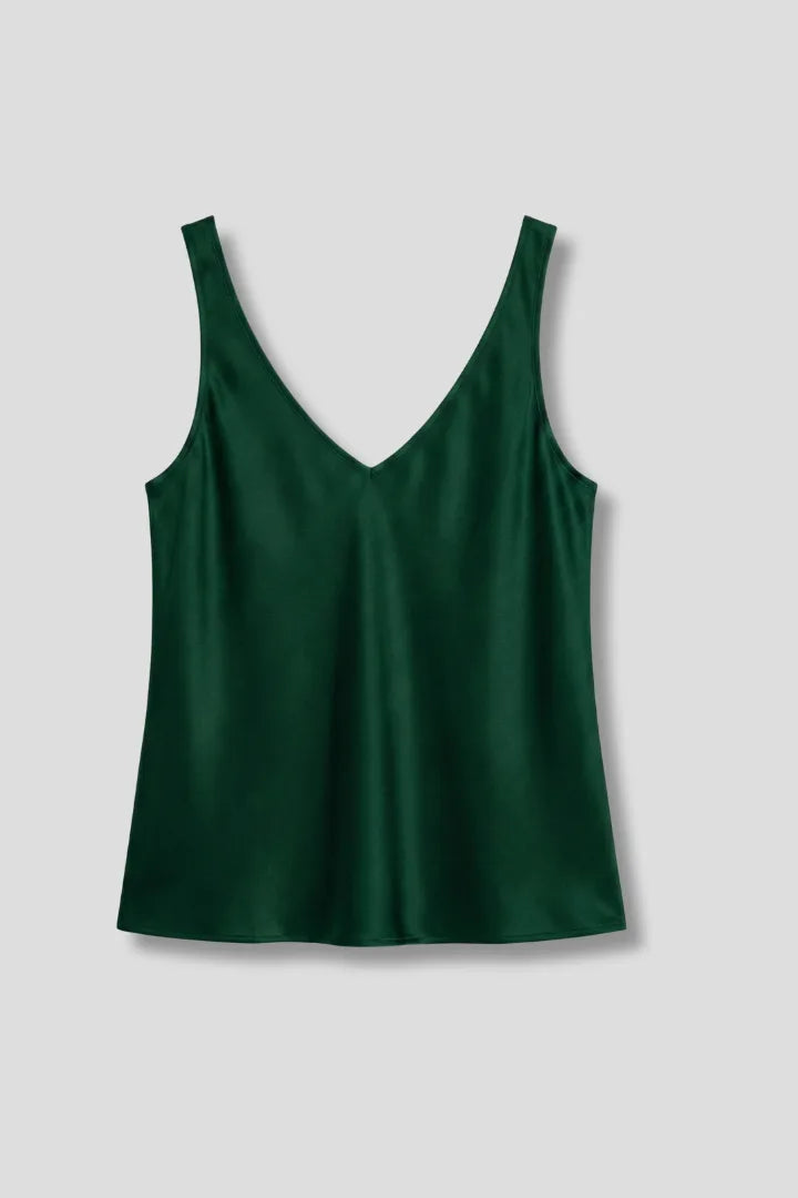 Flat lay of a dark green satin singlet with V-neck front and back, wide straps, on a grey background