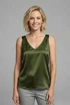 Woman wearing a rust orange satin singlet, three-quarter angle showing the straight hem