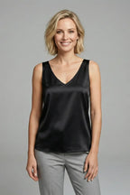 Close-up of the hem of an olive green satin singlet showing the straight cut finish