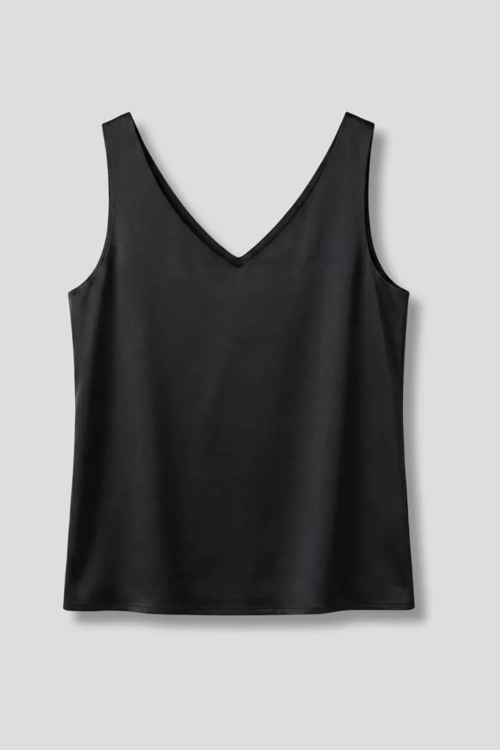 Close-up of dark green satin fabric showing the smooth sheen and V-neckline stitching detail