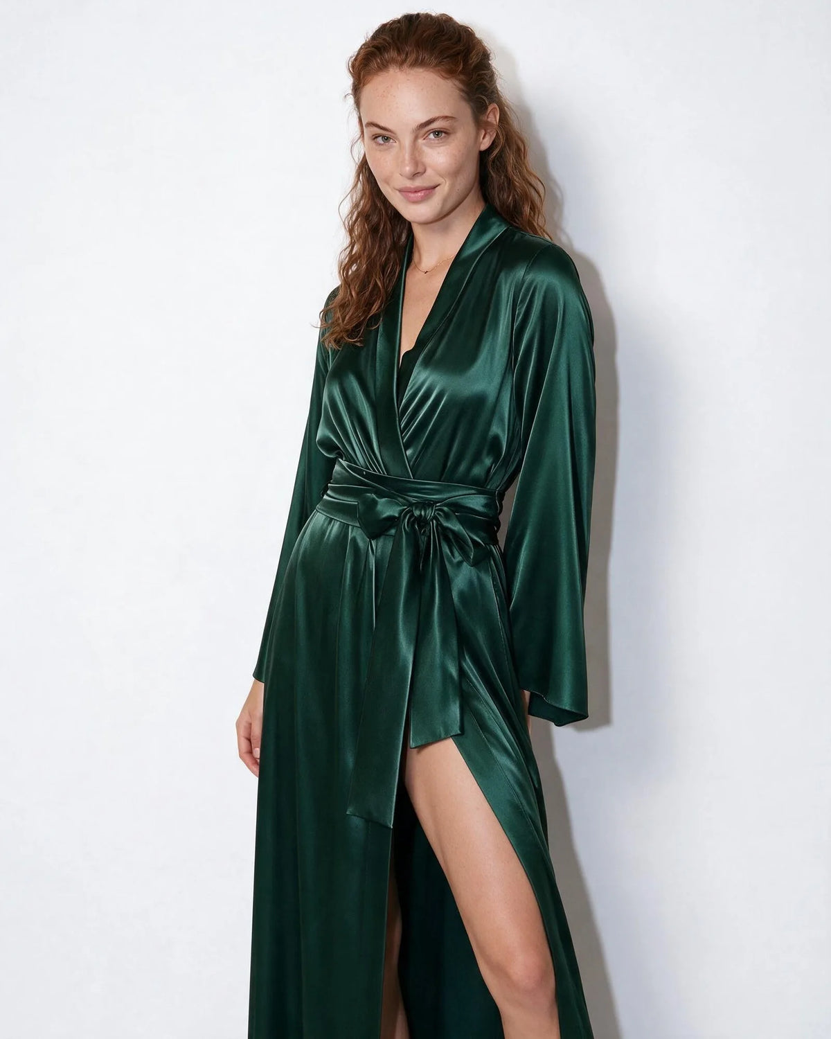 Front view of woman in red satin robe with V-neck wrap and long bell sleeves falling to the floor