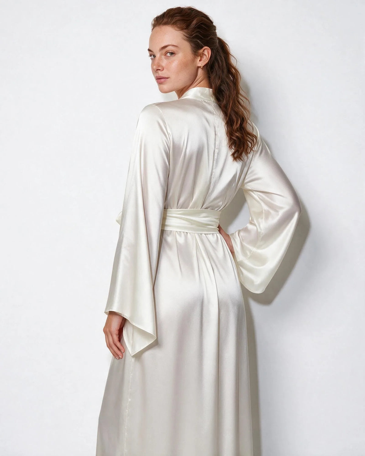 Woman in red satin robe walking, sleeve movement showing the fluid drape of the fabric