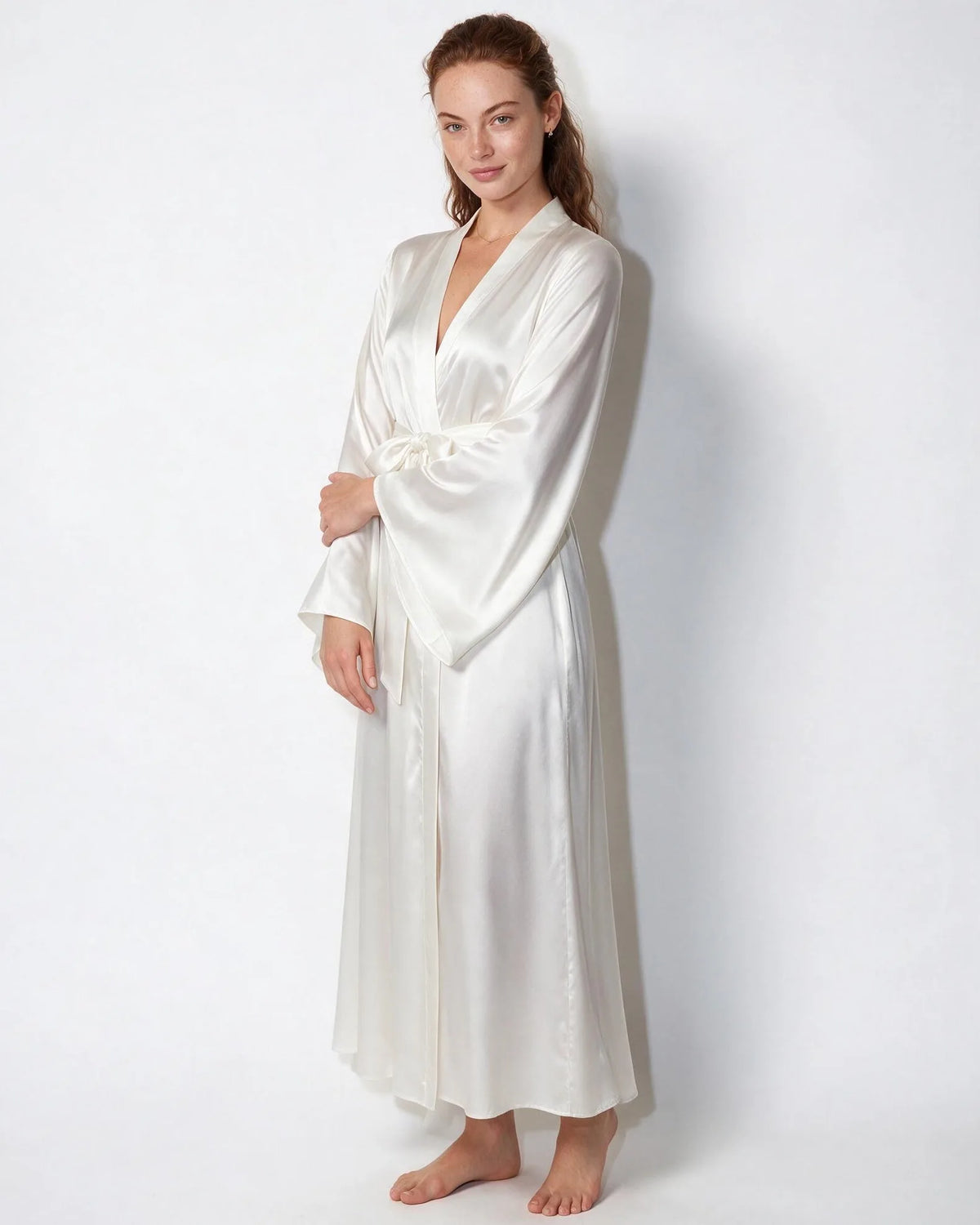Detail shot of the wrap front and sash tie on the red satin robe against a plain background