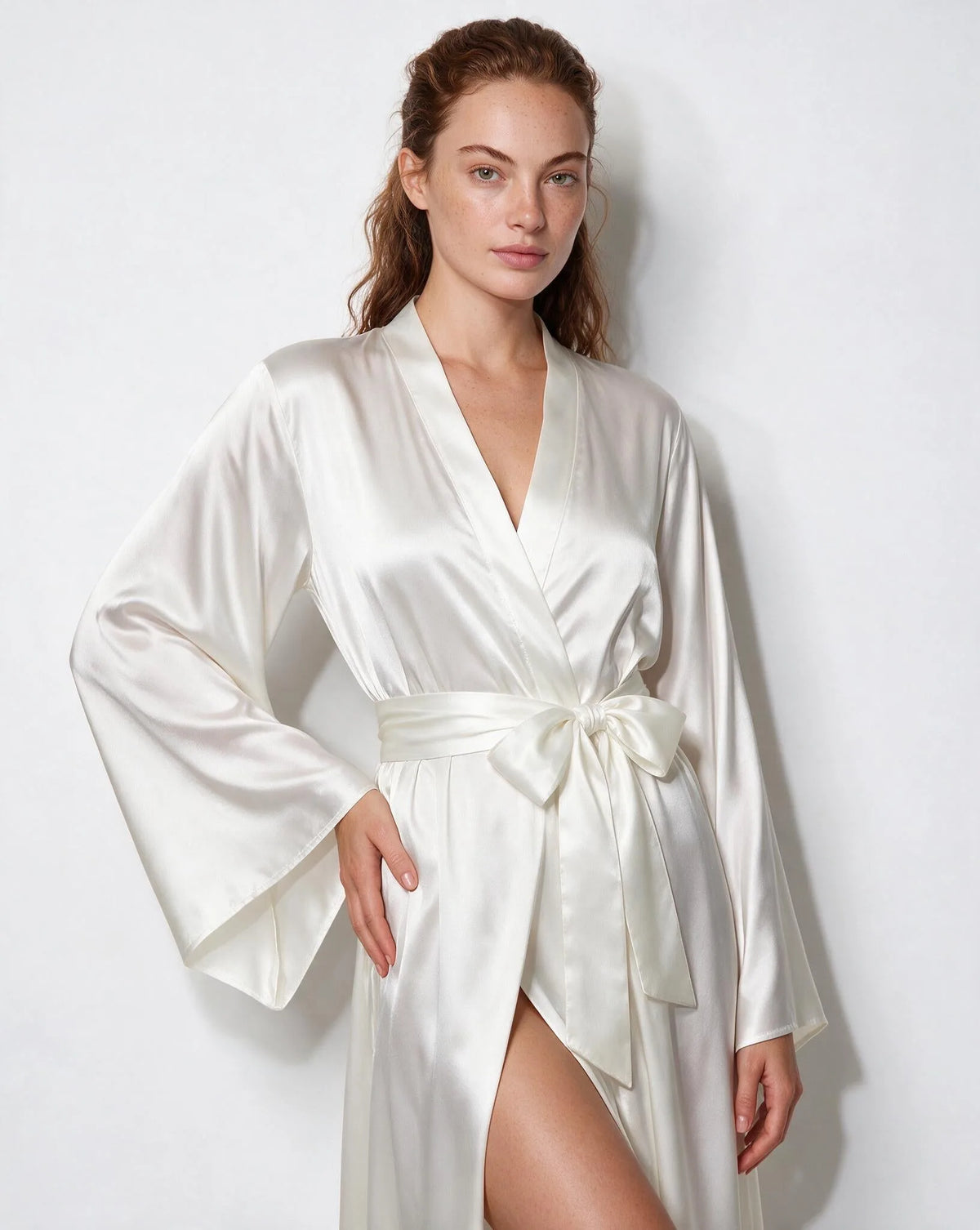 Close-up of the tied bow sash at the waist of the forest green satin robe