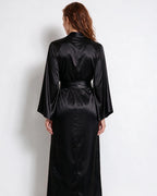 Detail of the flared sleeve cuff on the red satin robe, showing the wide bell shape
