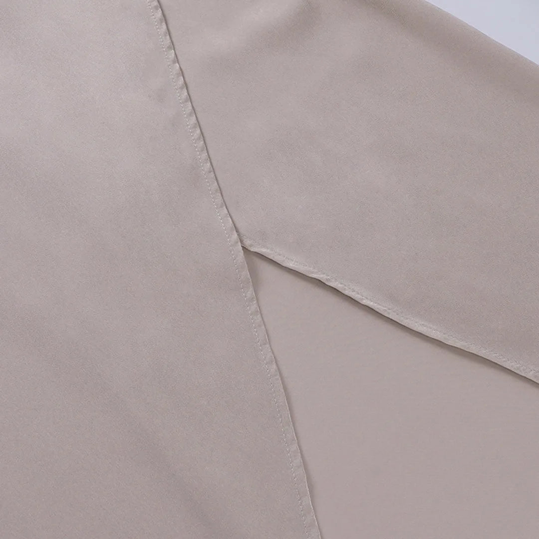 Overhead flat lay of the beige satin maxi dress laid flat, showing the fitted waist and wrap skirt