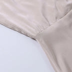 Close-up detail of the satin dress waistband seam showing the fitted silhouette construction