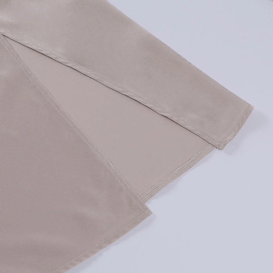 Detail shot of the thigh-high side slit on the satin maxi dress, showing the layered fabric opening