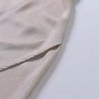 Close-up of the folded satin hemline showing the fine stitched edge and fabric drape
