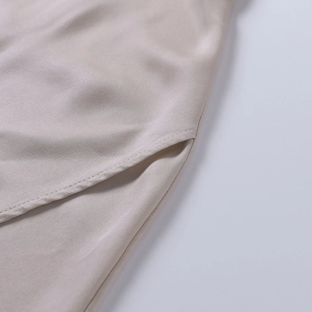 Close-up of the folded satin hemline showing the fine stitched edge and fabric drape